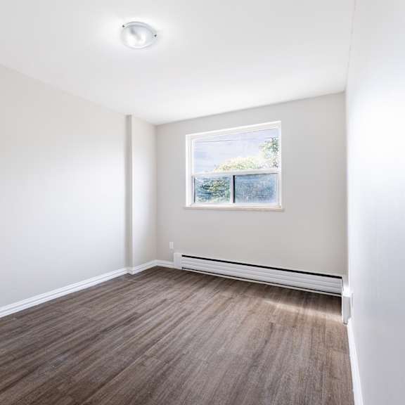 a room with a window and a picture on the wall.