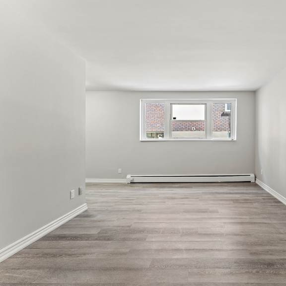 a room with a window and a white wall.