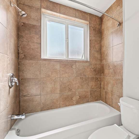 a bathroom with a tub, sink, and toilet.
