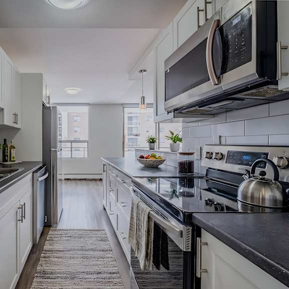 a kitchen with white cabinets and black countertops.