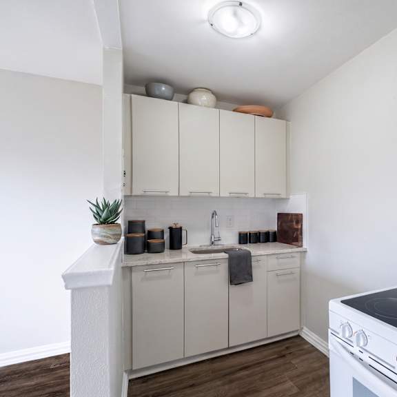 a white kitchen with a white oven and white cabinets.