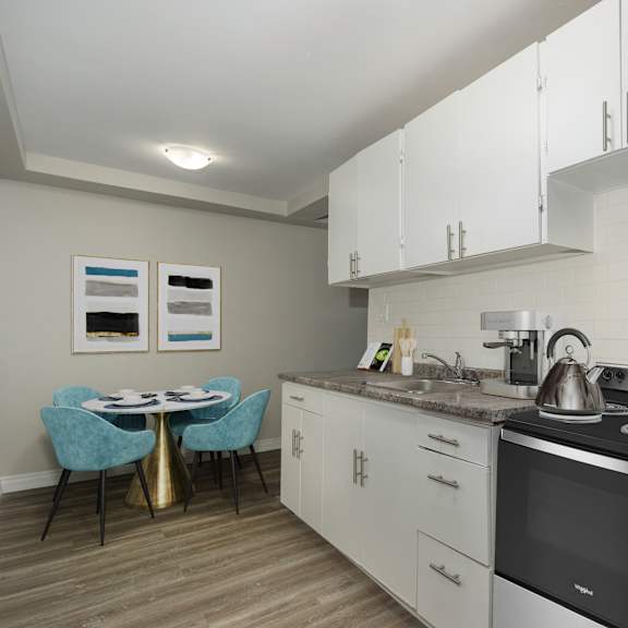 a kitchen with a table and chairs and a fridge.