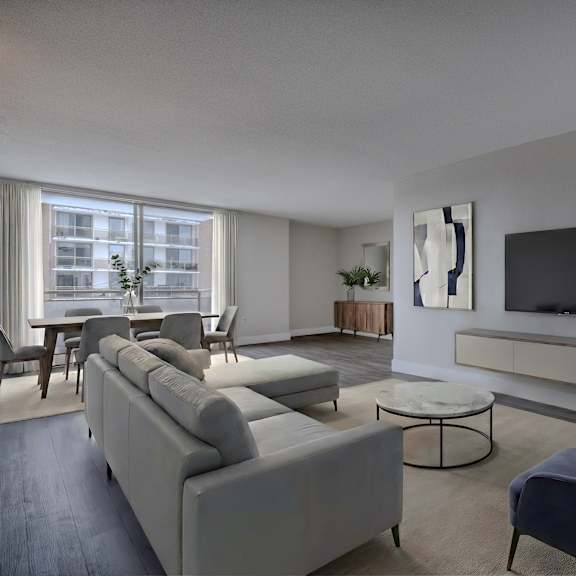 a living room with a grey sofa, a blue armchair, and a television on the wall.