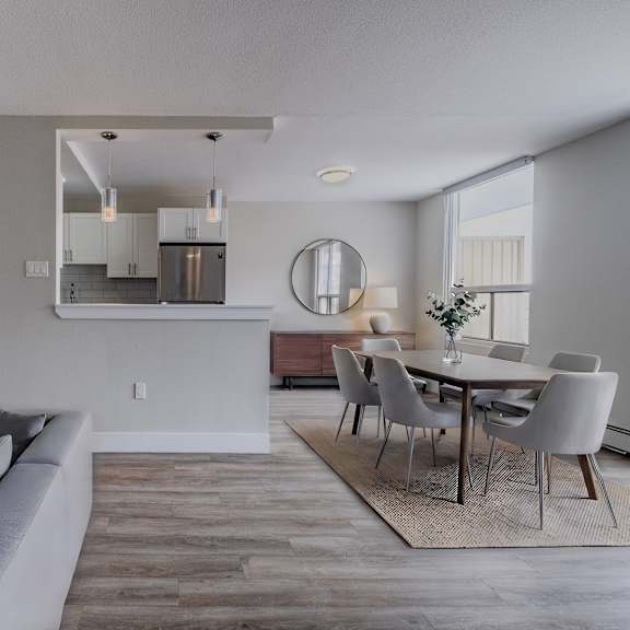 a modern living room with a grey sofa and a dining table set up.