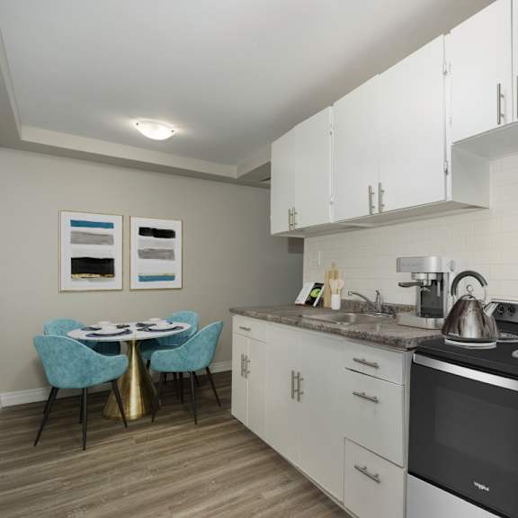 a kitchen with a table and chairs and a fridge.