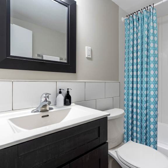 a white toilet sits next to a sink in a bathroom.