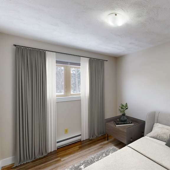 a modern bedroom with a grey bed, a small table with a plant, and a painting on the wall.
