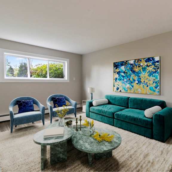 a living room with a green couch, two blue chairs, and a painting on the wall.