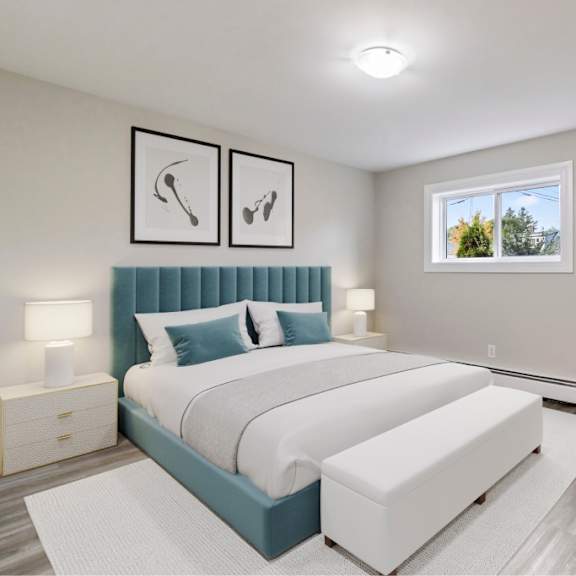 a bedroom with a large bed and a window showing trees outside.