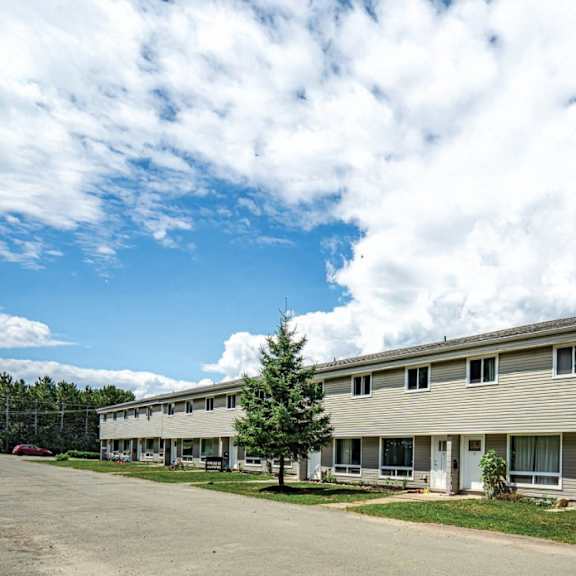 a long building with a parking lot in front.