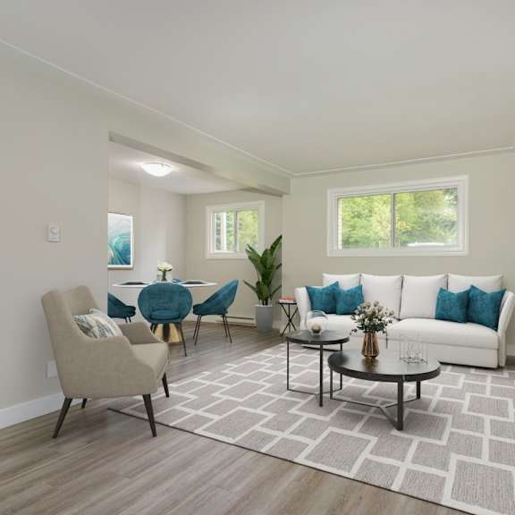 a living room with a white couch, a grey chair, and a coffee table.