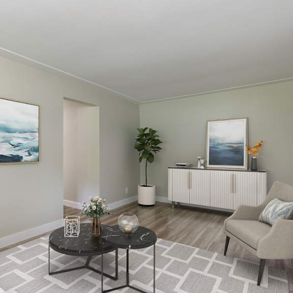 a living room with a white couch, a black coffee table, and two paintings on the wall.