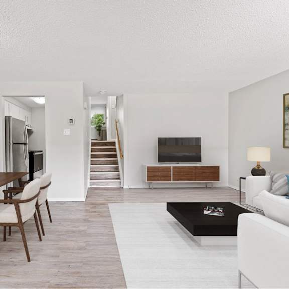 a modern living room with a dining table and a white couch.