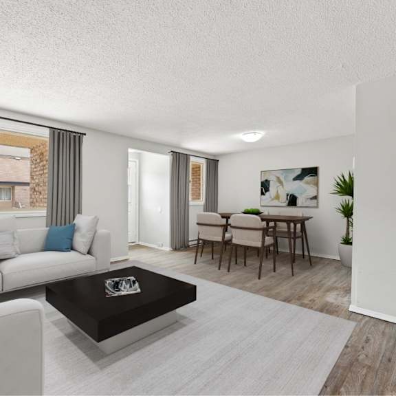 a living room with a grey sofa, a black coffee table, and a dining table with chairs.