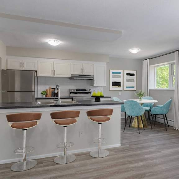 a kitchen with a bar area and a dining table with chairs.
