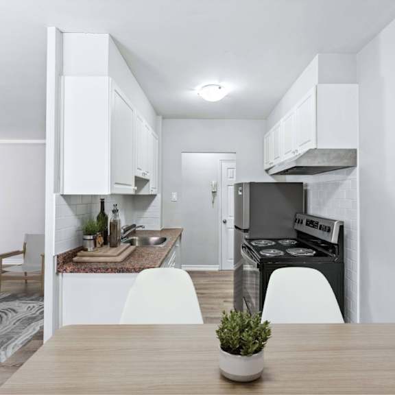 a modern kitchen with a wooden table and white chairs.