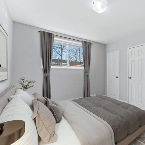 a bedroom with a large bed and a window with curtains.