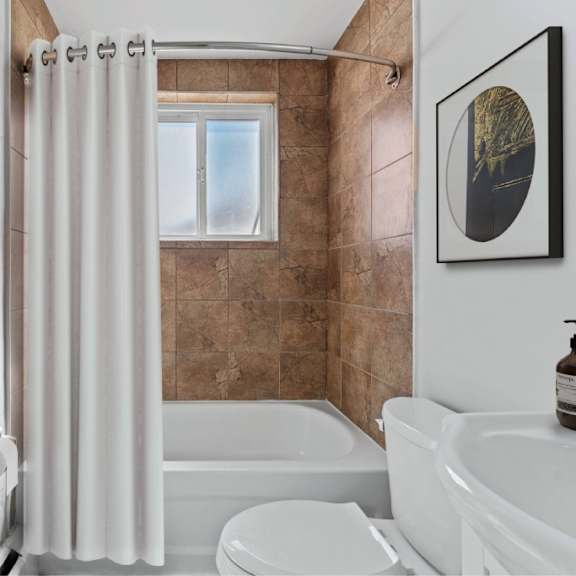 a bathroom with a white tub, toilet, and sink.
