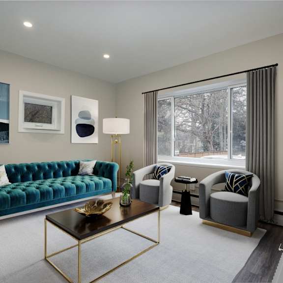 a living room with a green couch, a coffee table, and a window with curtains.