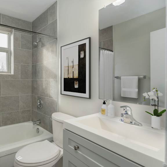 a bathroom with a white toilet, a white sink, and a shower with a white curtain.