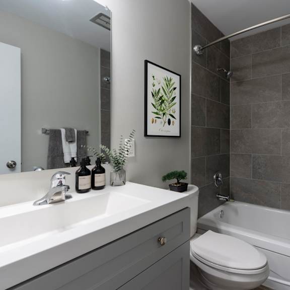 a bathroom with a white sink, a toilet, a bathtub, and a shower curtain.
