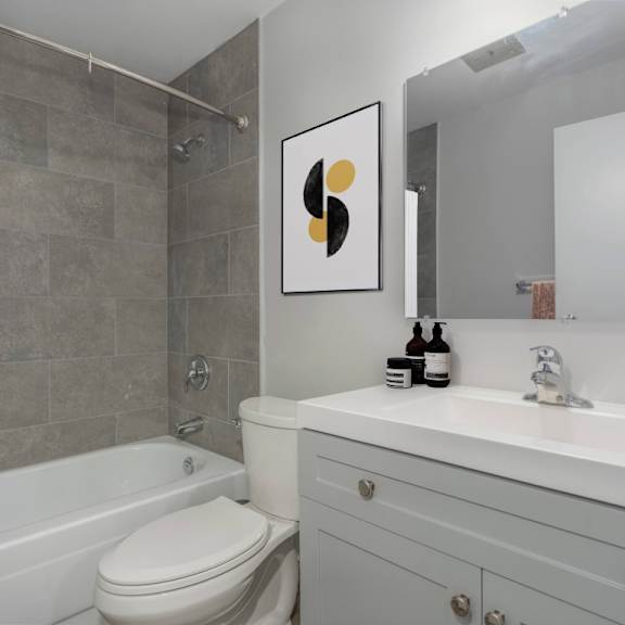 a bathroom with a toilet, sink, and shower.