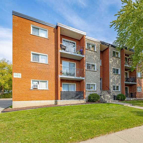 a red brick apartment building with a balcony on the second floor.