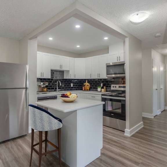 a kitchen with a refrigerator, island, and stove.