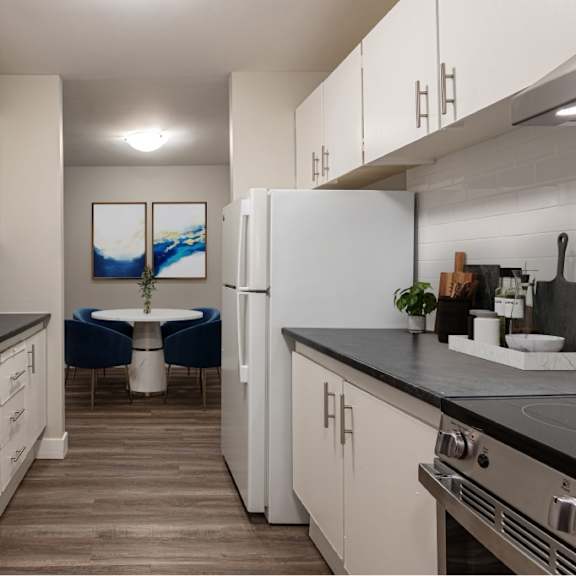 a modern kitchen with white cabinets and a black countertop.