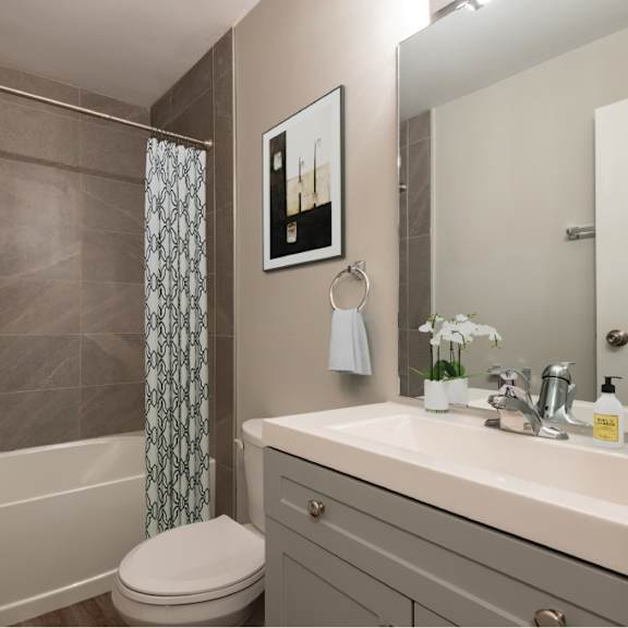 a bathroom with a toilet, sink, and shower.