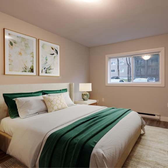 a bedroom with a bed, nightstand, and two framed pictures on the wall.