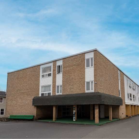 a large building with a parking lot in front.