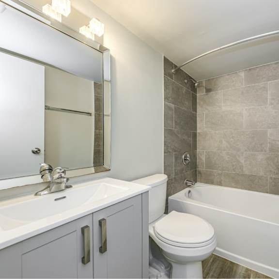 a bathroom with a white toilet, sink, and bathtub.