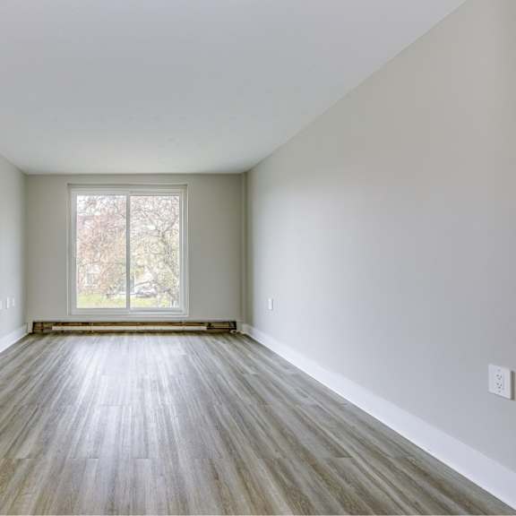 a room with wooden flooring and a large window.
