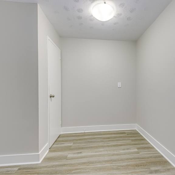 a room with a wooden floor and a white door.