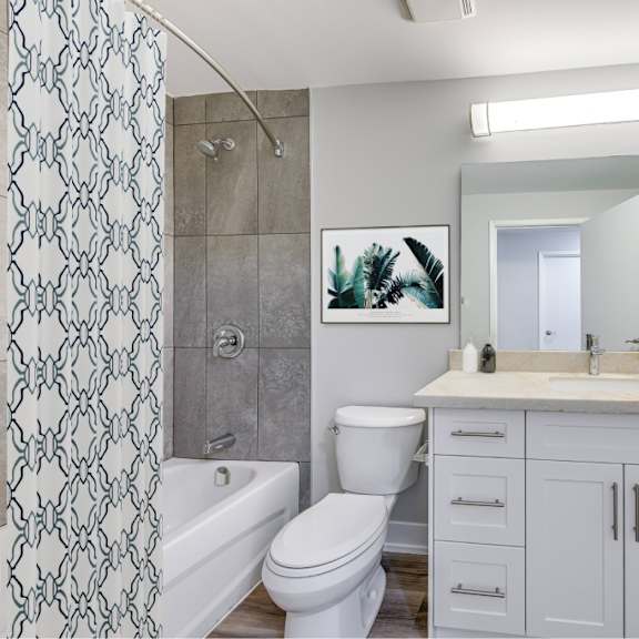 a bathroom with a toilet, sink, and shower.