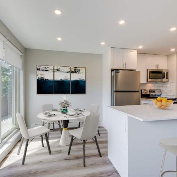 a modern kitchen with a dining table and chairs.