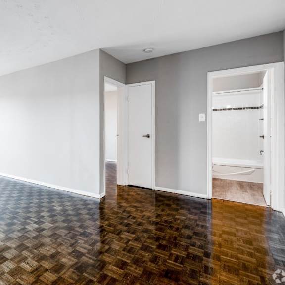 a room with a wooden floor and white walls.