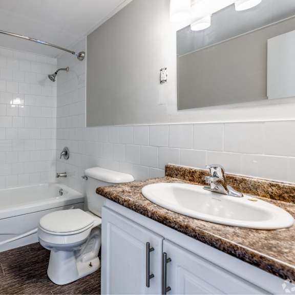 a white toilet sits next to a sink in a bathroom.