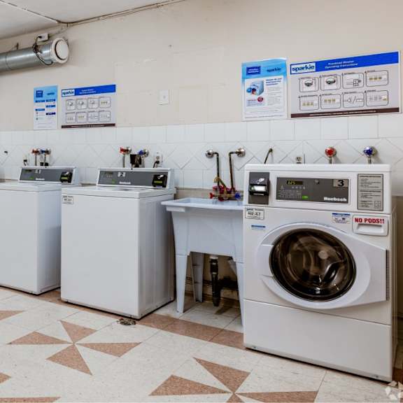 a laundry room with a washer and dryer on the right and a washing machine on the left.