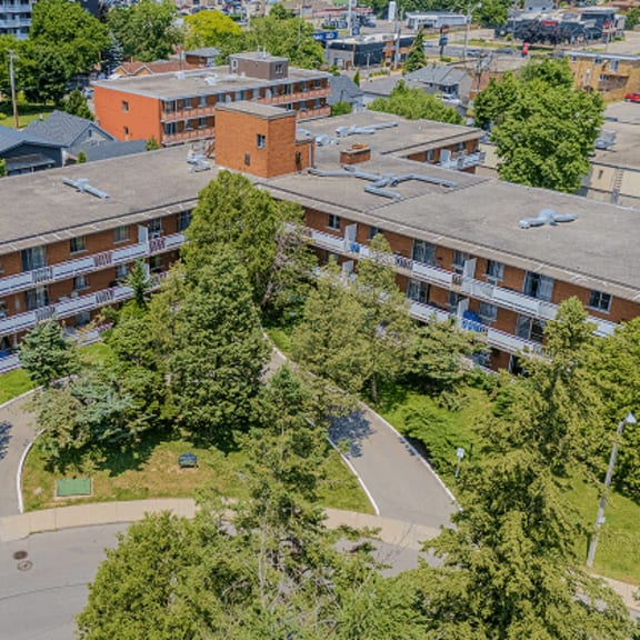 a large apartment complex with a green lawn in the middle.