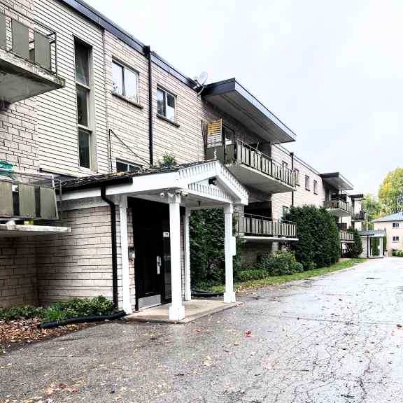a grey building with a white door and a balcony.