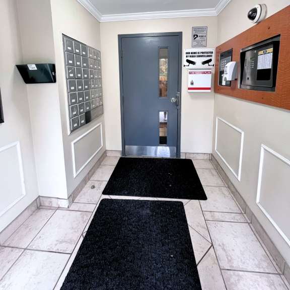 a hallway with a black carpet leading to a door.