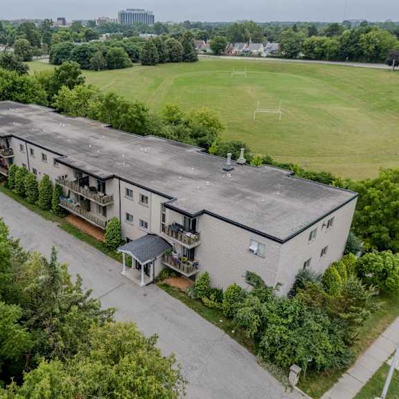 a large grey building with a green lawn in front.