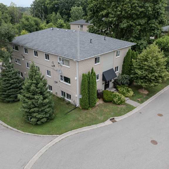 a large house with a grey roof and a driveway in front.