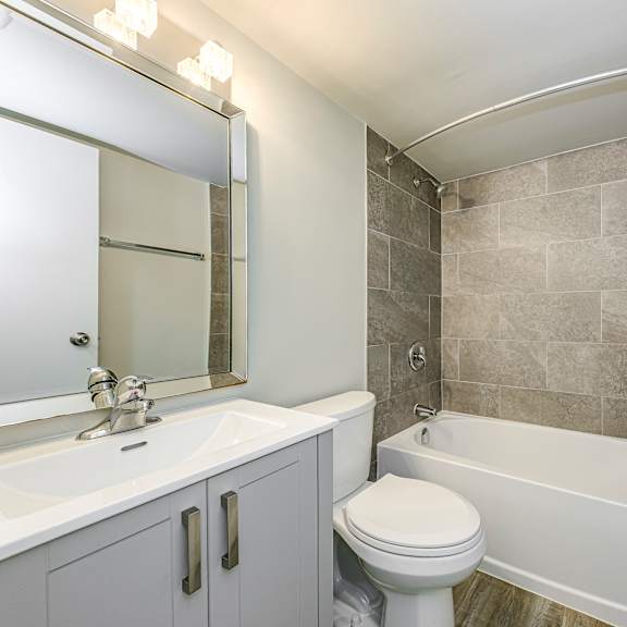 a bathroom with a white toilet, sink, and bathtub.
