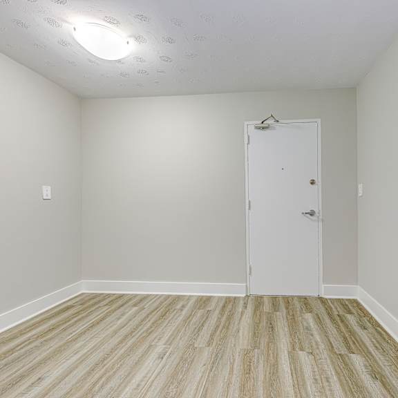 a room with a white door and wooden flooring.