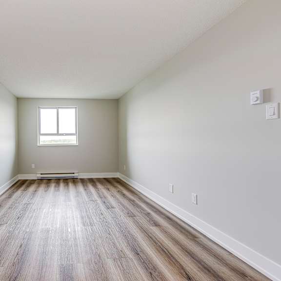 a room with wooden floors and a window in the middle.