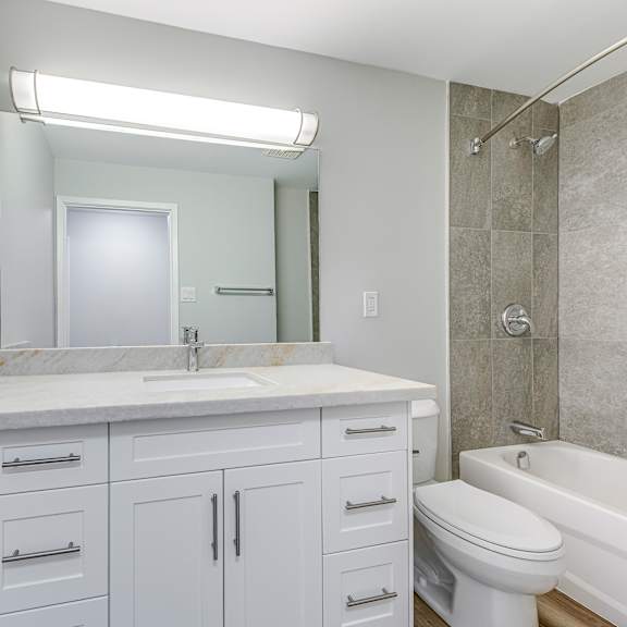 a white bathroom with a sink, toilet, and bathtub.