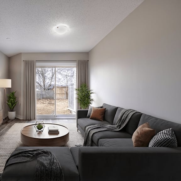 a modern living room with a grey sofa, a wooden coffee table, and a large window with a view of a tree.
